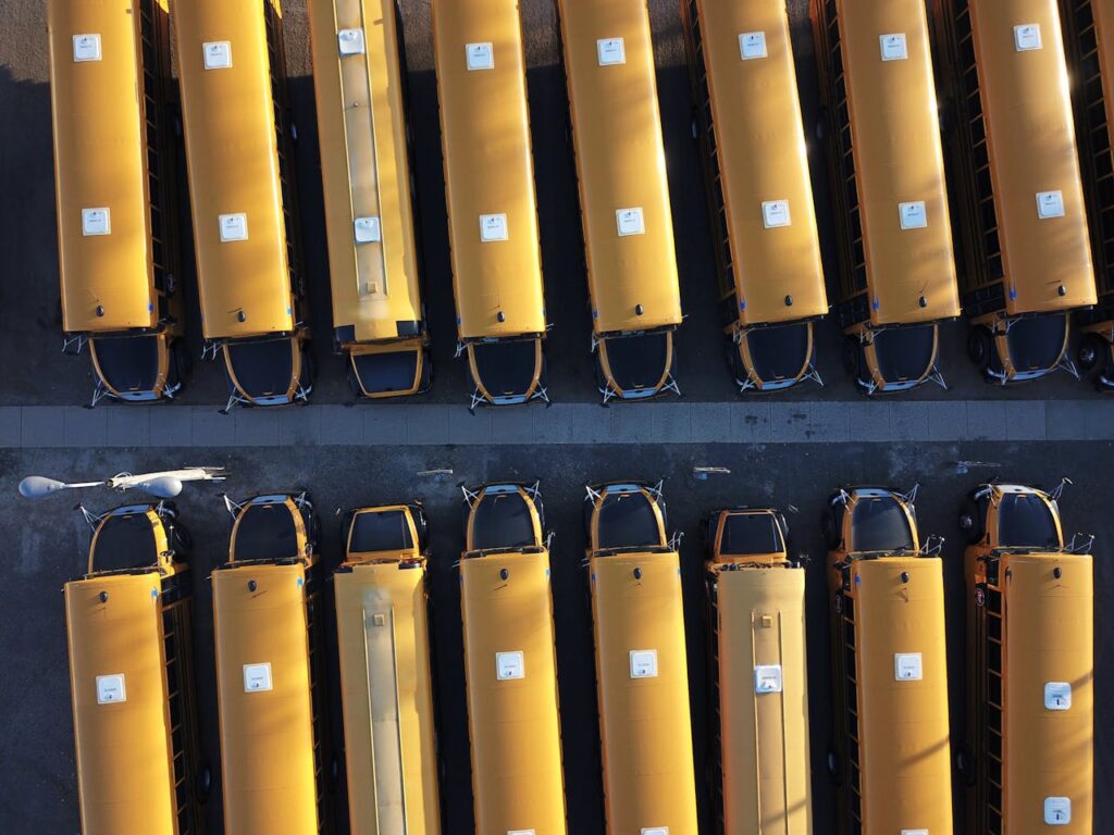 Aerial view of neatly parked yellow school buses in Mound, MN on a sunny day.